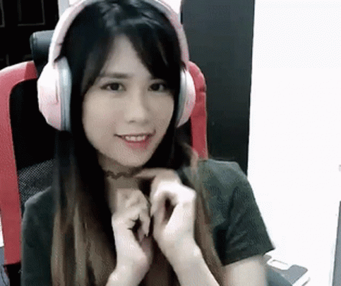 A Young Woman Wearing Headphones Is Sitting In A Chair . GIF