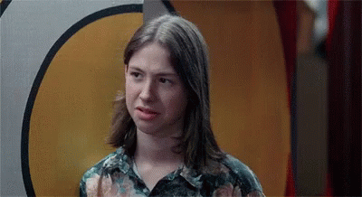 A Young Woman With Long Hair Is Making A Funny Face . GIF