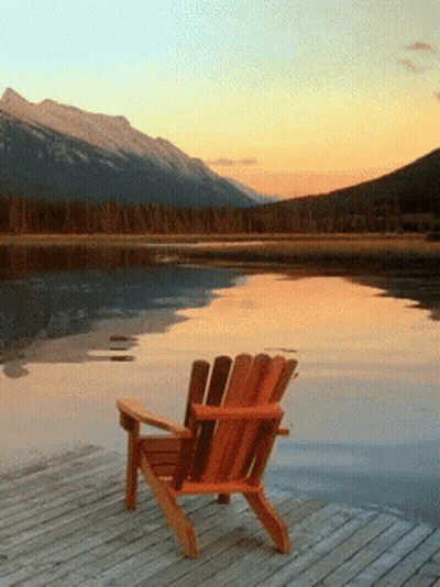 Adirondack Chair On Dock Overlooking Lake At Sunset GIF
