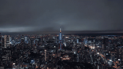 Aerial View Of City At Night With Blue Skyscraper GIF