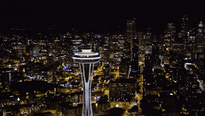 Aerial View Of City At Night With Space Needle Lit Up GIF