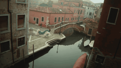 Aerial View Of Narrow Canal With Boats And Buildings GIF