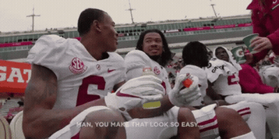Alabama Football Players Sitting On Sidelines GIF