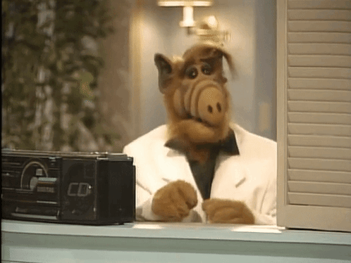 Alf From The Sitcom Sits In Front Of A Radio That Says Cd GIF