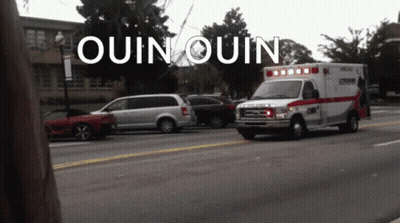 Ambulance Driving Down Street With Quin Quin GIF