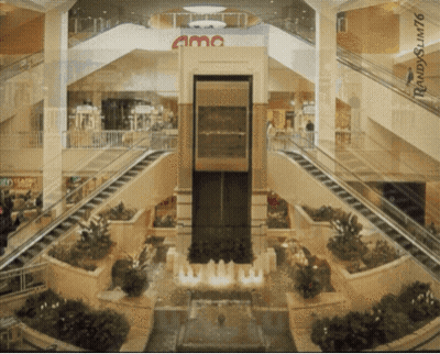AMC Sign Above Escalators In Mall GIF