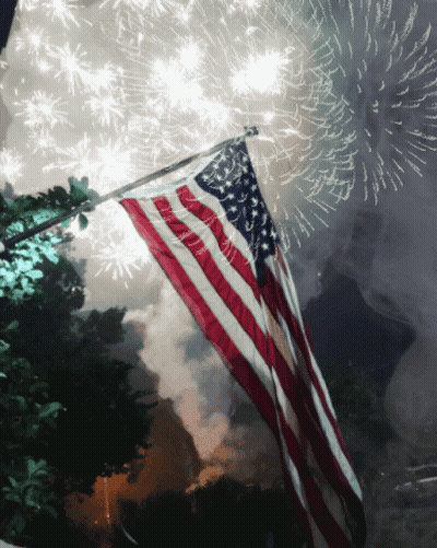 American Flag Flying In Front Of Fireworks GIF