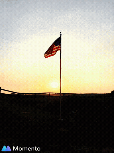 American Flag Silhouetted Against Sunset With Momento Logo GIF