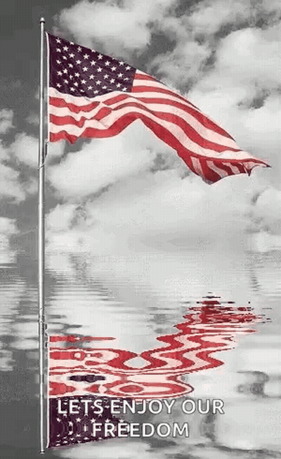 American Flag Waving Against Cloudy Sky Reflected In Water GIF