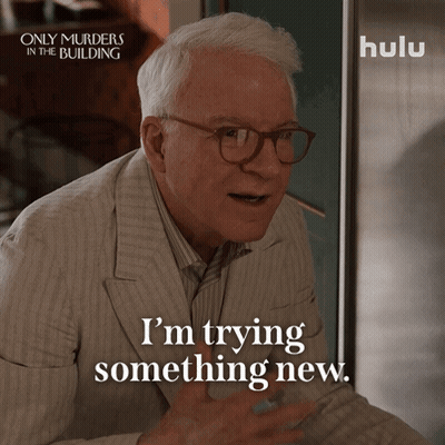 An Advertisement For Only Murders In The Building Shows A Man In A Suit And Glasses Saying I 'M Trying Something New GIF
