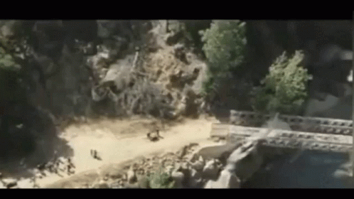 An Aerial View Of A Bridge Over A River In The Middle Of A Forest . GIF