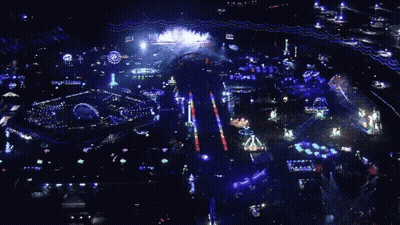 An Aerial View Of A Carnival At Night With A Ferris Wheel In The Background GIF
