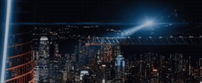 An Aerial View Of A City At Night With Lots Of Buildings Lit Up GIF