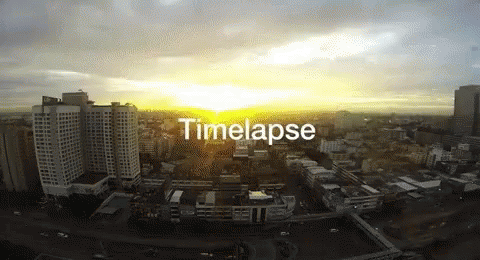 An Aerial View Of A City At Sunset With The Words Timelapse Below It GIF