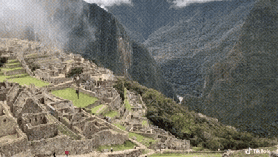 An Aerial View Of A City In The Middle Of A Mountain Range GIF