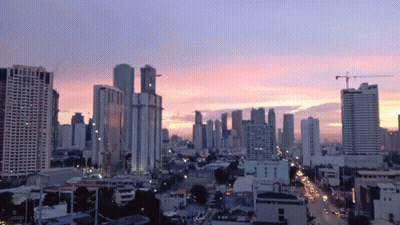 An Aerial View Of A City Skyline At Sunset With A Pink Sky In The Background GIF