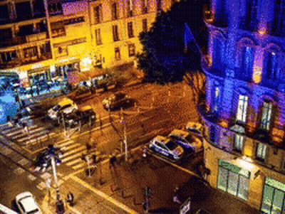 An Aerial View Of A City Street At Night With Cars Parked On The Side Of The Road GIF
