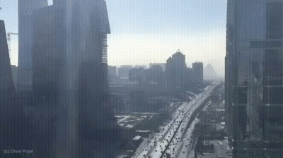 An Aerial View Of A City With A Highway And A Lot Of Traffic . GIF