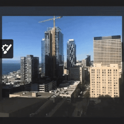 An Aerial View Of A City With A Large Crane In The Distance GIF