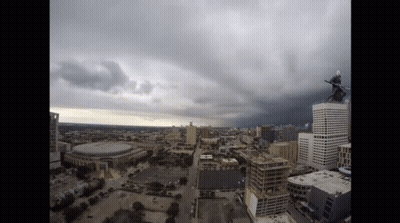 An Aerial View Of A City With A Person On Top Of A Tall Building GIF