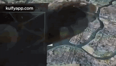 An Aerial View Of A City With A River Running Through It And A Large Hole In The Ground . GIF