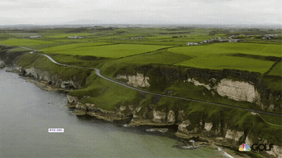 An Aerial View Of A Cliff With A Sign That Says ' The Open ' On It GIF