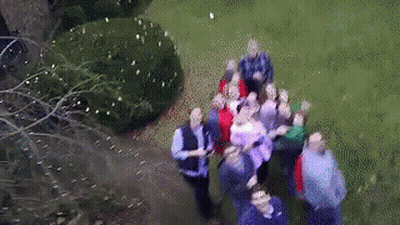 An Aerial View Of A Group Of People Standing On A Grassy Field GIF