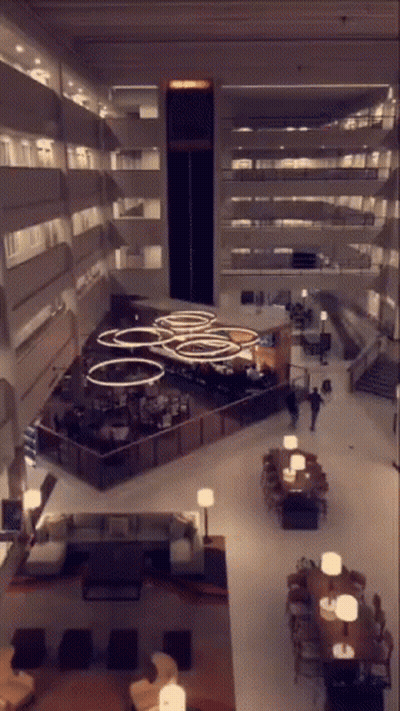 An Aerial View Of A Hotel Lobby With Tables Chairs And Lamps GIF