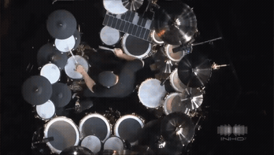 An Aerial View Of A Man Playing Drums In A Dark Room With The Word Inhd In The Corner GIF