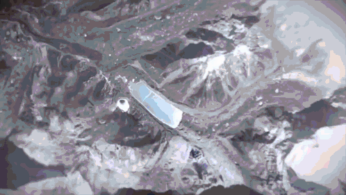 An Aerial View Of A Mountain Range With A White Object In The Foreground GIF