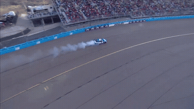 An Aerial View Of A Race Track With A Car That Has Smoke Coming Out Of Its Tires GIF