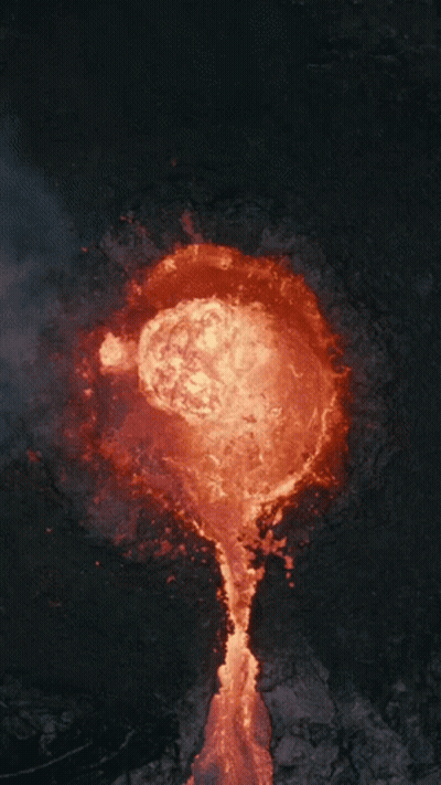 An Aerial View Of A Volcano With Lava Coming Out Of The Crater GIF