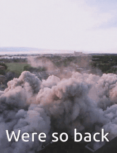 An Aerial View Of Smoke Coming Out Of A Building With The Words Were So Back Below It GIF