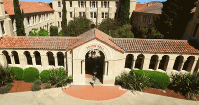 An Aerial View Of Toyen Hall With A Girl Walking Through The Entrance GIF