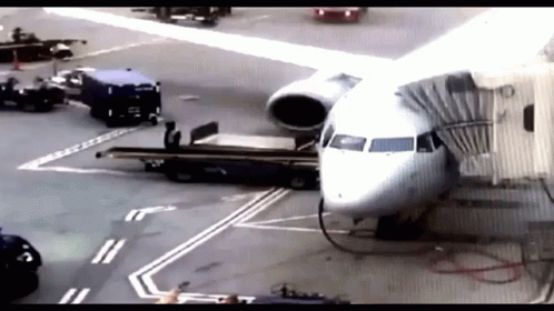 An Airplane Is Being Loaded With Luggage At An Airport Terminal GIF