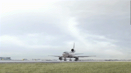An Airplane Is Taking Off From A Runway With A Cloudy Sky Behind It GIF