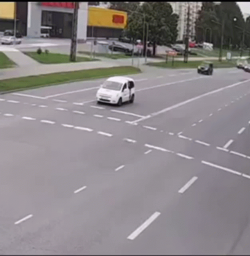 An Ambulance Is Driving Down A Street Next To A Bicycle That Has Fallen Off The Road . GIF
