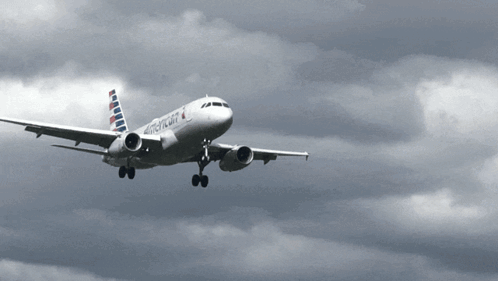 An American Airlines Plane Is Flying In The Clouds GIF