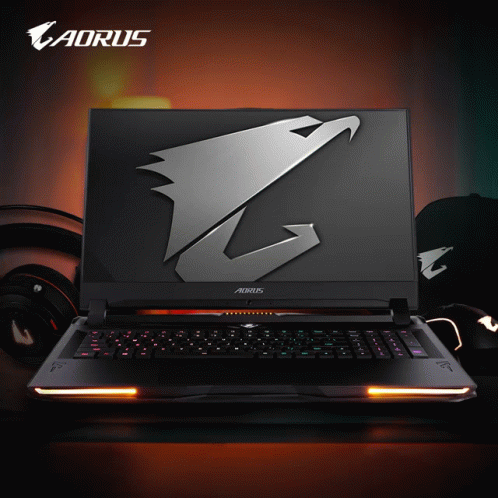 An Aorus Laptop Sits On A Table With Headphones GIF