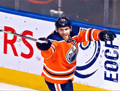 An Edmonton Oilers Hockey Player Holds His Stick Up In The Air GIF