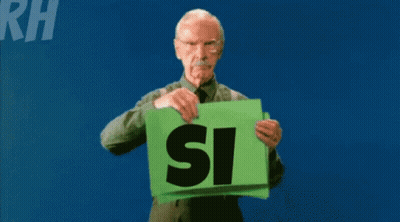 An Elderly Man Holds A Green Sign That Says Si Si GIF
