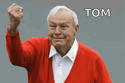 An Elderly Man In A Red Sweater Is Holding His Fist Up In The Air And Says Tom . GIF
