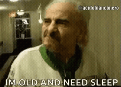 An Elderly Man Is Standing In A Room And Says `` I 'M Old And Need Sleep '' . GIF