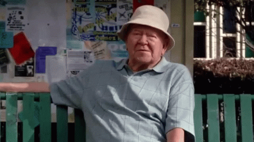 Elderly Man Sitting On Bench In Front Of Sydney Sign GIF