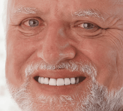 an elderly man with a beard and white teeth smiles