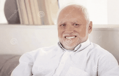 An Elderly Man With A Beard Is Smiling And Sitting On A Couch GIF