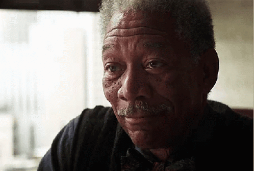An Elderly Man With A Mustache Is Smiling And Looking At The Camera GIF