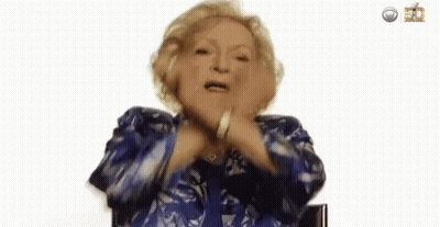 An Elderly Woman In A Blue Jacket Is Making A Funny Face And Dancing . GIF
