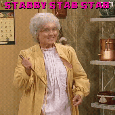 An Elderly Woman In A Yellow Coat Is Holding A Wand In Front Of A Sign That Says Stabby Stab Stabd GIF