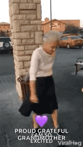An Elderly Woman Is Dancing In A Parking Lot With A Purple Heart . GIF